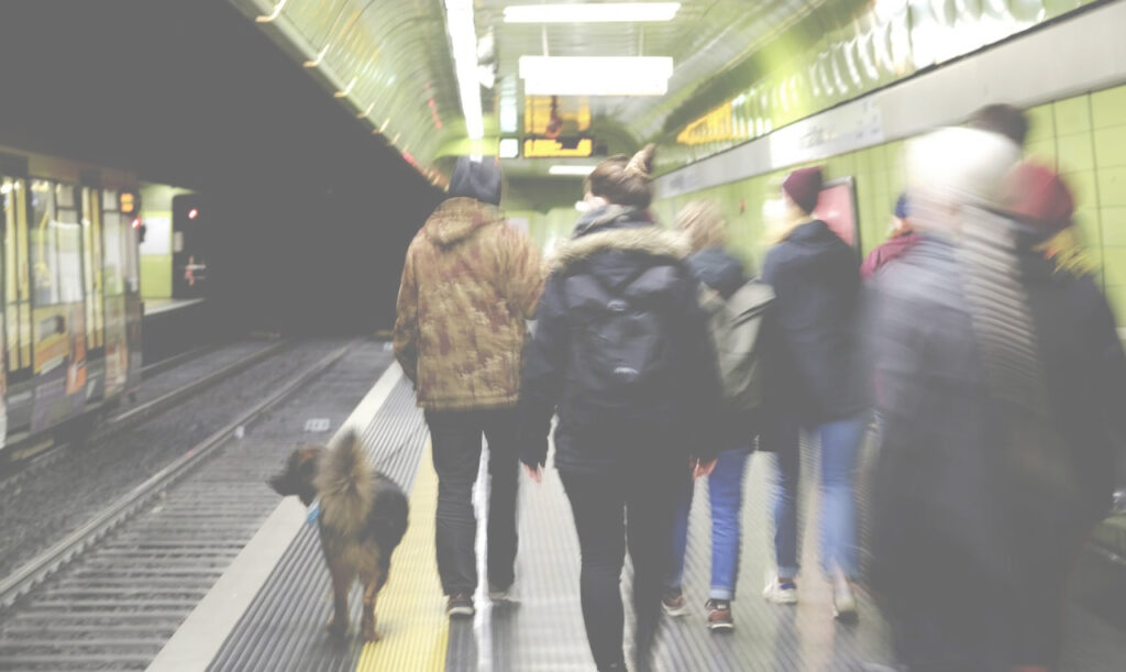 Eine Stadtstreiferin mit Hund führt eine Gruppe durch eine Bonner U-Bahn Station.