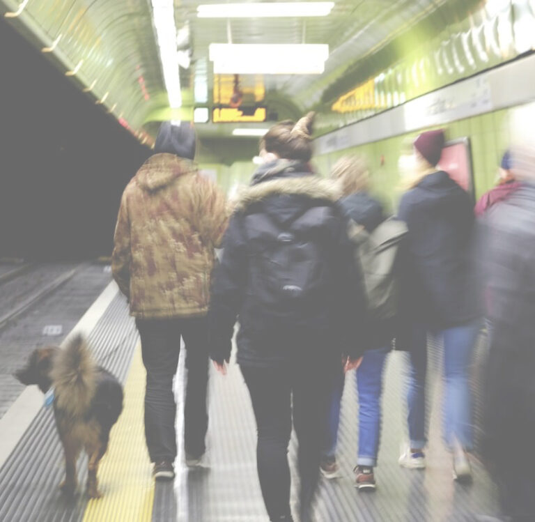 Eine Stadtstreiferin mit Hund führt eine Gruppe durch eine Bonner U-Bahn Station.